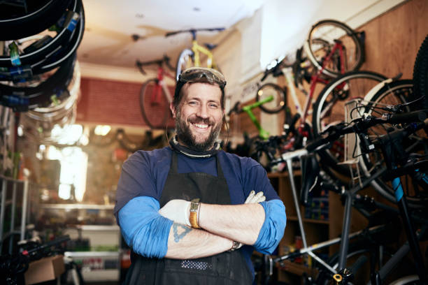 Bring all your bike repairs and maintenance jobs to me Shot of a handsome man working in his self-owned bicycle workshop repairperson occupation stock pictures, royalty-free photos & images