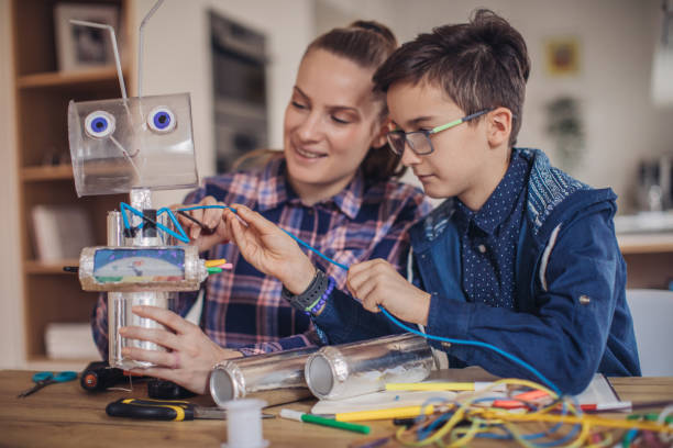 istock Teacher and young boy making a robot together 1131997591
