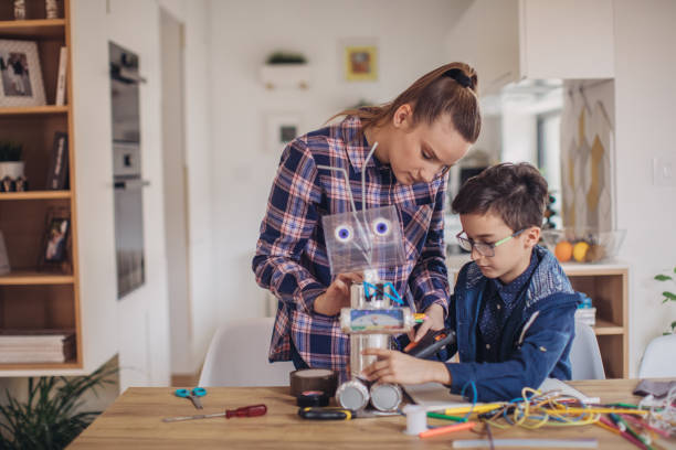 istock Lady teacher and boy making a robot together 1131998186
