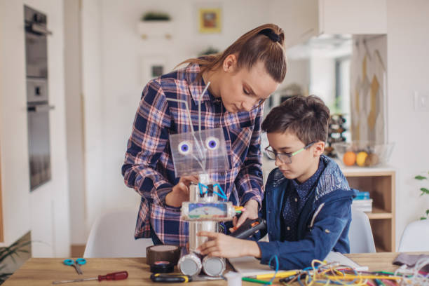 istock Woman teacher and boy making a robot together 1131998206