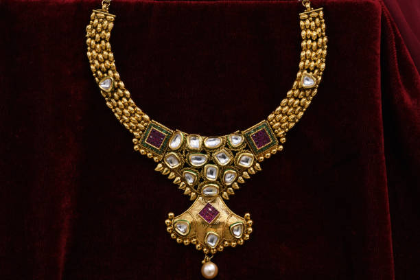 istock Fancy designer golden neckset closeup macro image on red background. 1131999287