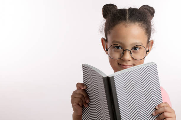 istock Little girl sitting with a book. Isolated over white 1132000021