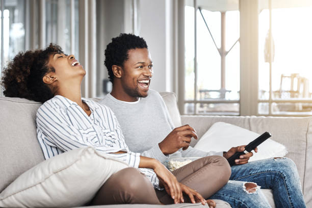 It’s not a cinema but it’s every bit as good Shot of a happy young couple watching tv together at home watching tv stock pictures, royalty-free photos & images