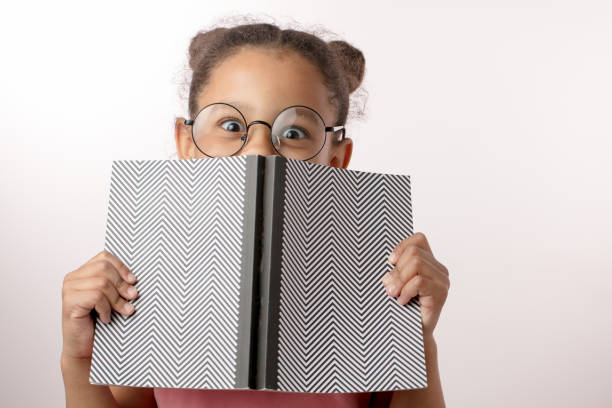 istock cheerful black-haired girl laughing behind the notepad 1132000276