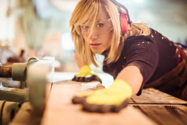 istock Woman woodworker using a saw guide to cut a wooden plank on a work bench 1132002069