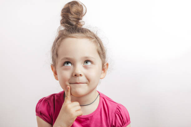 zamyślająca przebiegła dziewczyna patrząca w górę i myśląca o czymś - hair bun hairstyle beautiful looking zdjęcia i obrazy z banku zdjęć