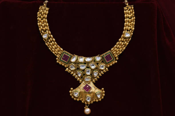 istock Fancy designer golden neckset closeup macro image on red background. 1132003738