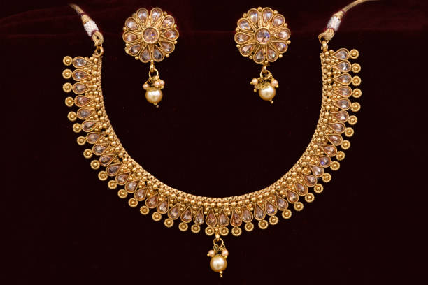 istock Fancy designer golden neckset closeup macro image on red background. 1132003851