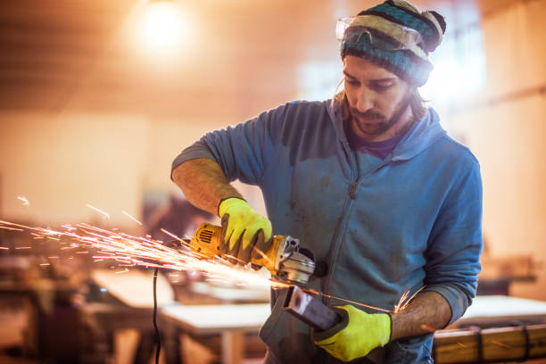 istock Mechanic using a powered hand grinder to grind a metal pipe in a steel workshop 1132004002