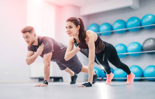 istock Pretty young couple doing exercises together in the light gym. 1132004190