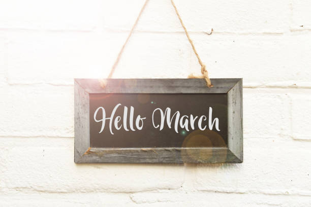 istock Hello March hand lettering on hanging sign board in spring sunlight 1132004281