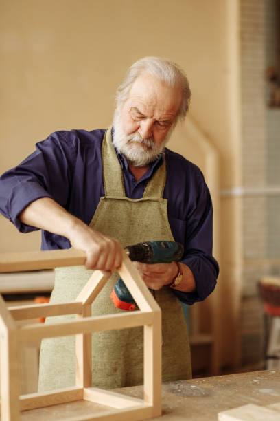 istock small business. senior carpenter building feed bunk for birds 1132005831