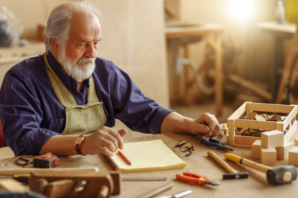 istock old experienced carpenter sitting at the messy table at workplace 1132005878