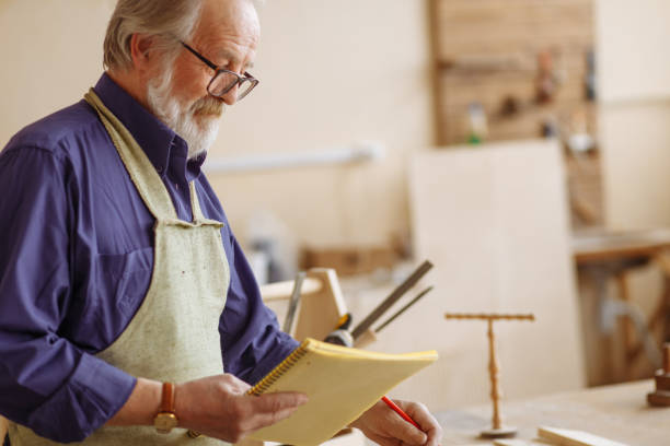 istock grey headed craftsman in glasses counting his tools 1132005998