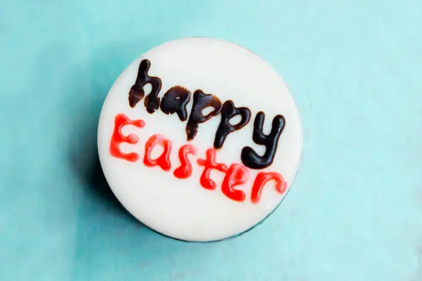Top view of white chocolate written with happy Easter text on the table