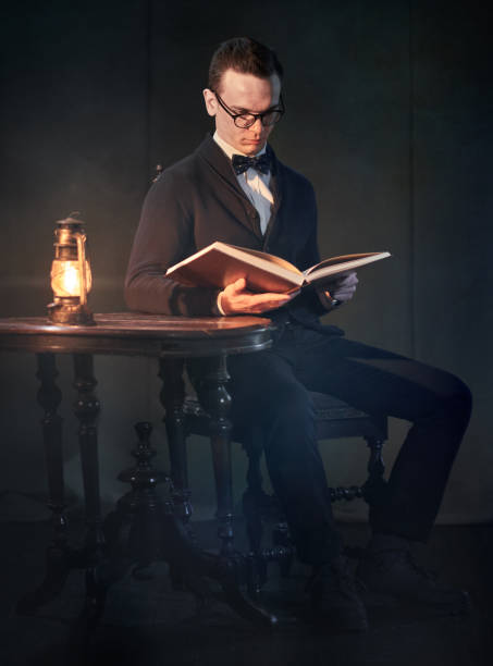 istock Cute Young Man In Bow Tie Is Reading Book 1132006102