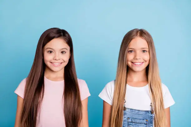 Photo of Close-up portrait of two people nice-looking sweet tender attractive beautiful cheerful straight-haired girls siblings isolated over blue pastel background