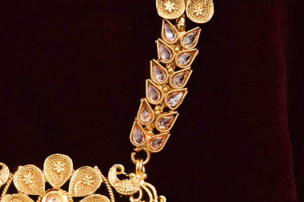 istock Fancy designer golden neckset closeup macro image on red background. 1132006149