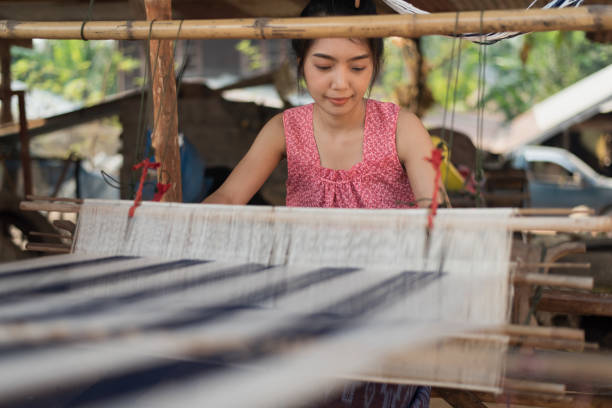 istock Young women weaving with traditional Thai weaving machine 1132006232