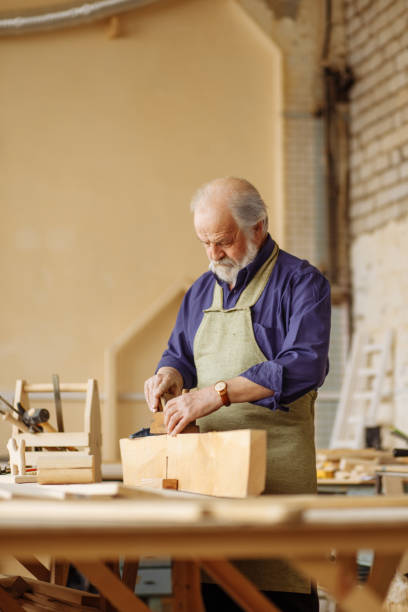 istock old shop teacher showing how use plane while working with timber 1132007669