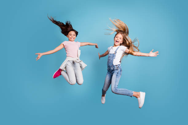 Full length body size view of two people nice lovely attractive cheerful straight-haired pre-teen girls having fun day daydream yes goal achievement free time isolated on blue background Full length body size view of two people nice lovely attractive cheerful straight-haired pre-teen girls having fun day daydream yes goal achievement free time isolated on blue background. trampoline stock pictures, royalty-free photos & images