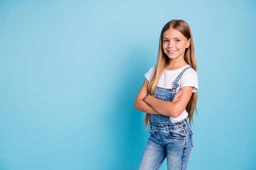 Portrait of her she nice-looking cute lovely attractive cheerful cheery straight-haired blonde girl folded arms copy space isolated on blue pastel background.