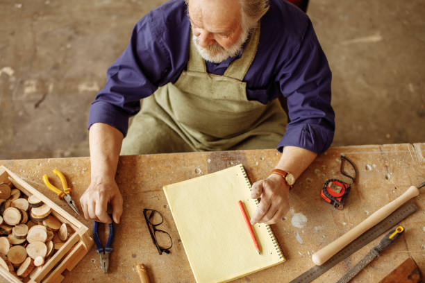 istock senior citizen sitting at the desk which is cluttered with instruments 1132010895