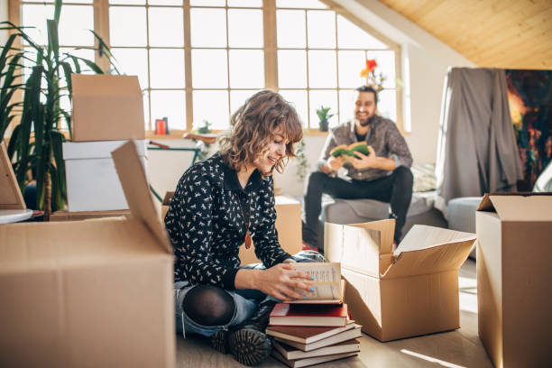 istock Couple sitting in new home around unpacked boxes 1132012172