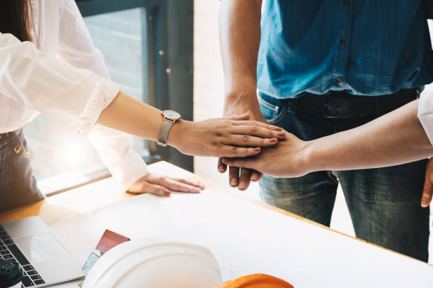 istock Businessmen and engineers join hands to build successful projects. Teamwork concept 1132012483