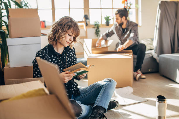 istock Young couple sitting in new home around unpacked boxes 1132012595