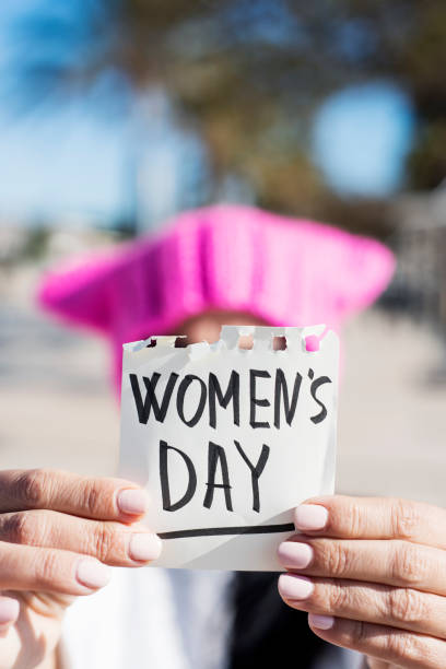 istock woman with a pink hat and the text womens day 1132012768