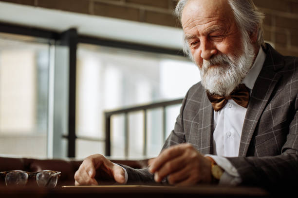 cerrar foto de tipo feliz viejo hombre mirando a su teléfono inteligente - human eye tired rubbing businessman fotografías e imágenes de stock