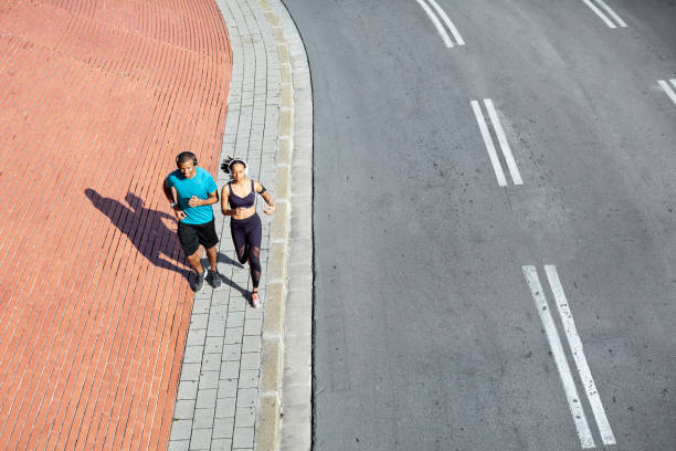 istock Couple jogging on sidewalk during sunny day 1132013638