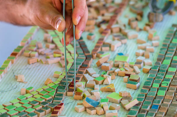 istock The man organizes with a tweezers a puzzle of ceramic elements for the construction of ceramic artworks. 1132017441