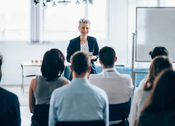Business seminar Businesswoman leading a training class for professionals showing stock pictures, royalty-free photos & images