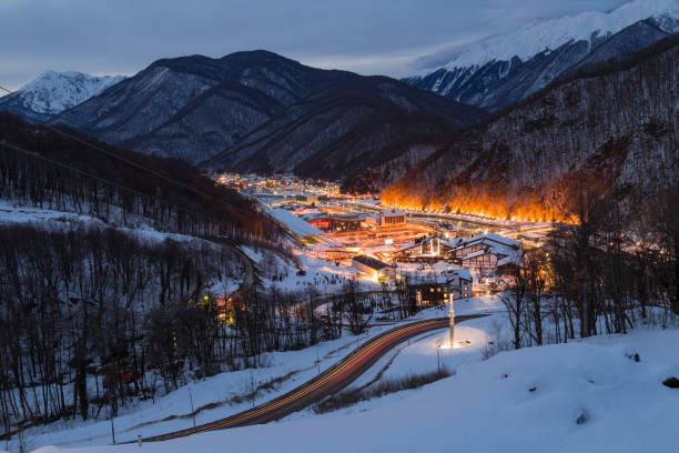 горнолыжный курортный город красная поляна, улица  горького окружена снежными вершинами на высоте 540 и 960 метров - сочи стоковые фото и изображения
