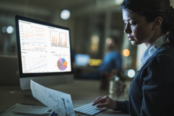 istock Young businesswoman reading reports while working late on PC in the office. 1132019026