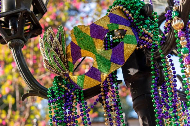 abalorios de mardi gras al aire libre y máscara en poste ligero - mardi gras fotografías e imágenes de stock