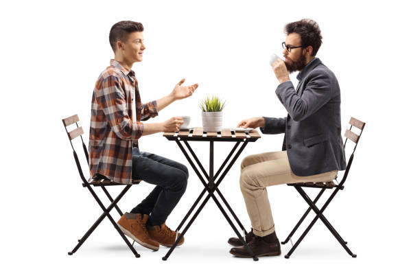 istock Young guy in a cafe talking to a bearded man drinking coffee 1132019520