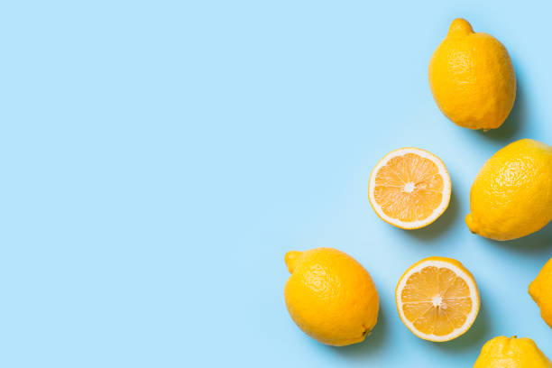 istock Ripe lemons flat lay with leaves on blue background 1132020328