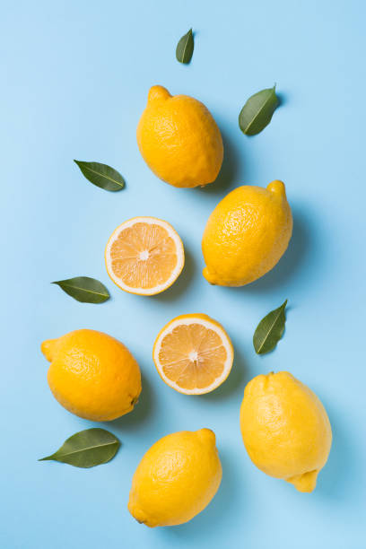 istock Ripe lemons flat lay with leaves on blue background 1132020340