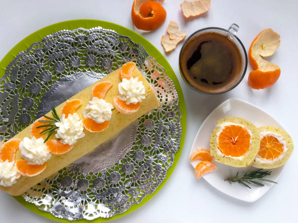 istock Cooking biscuit roll stuffed with ricotta and mandarin. Ready roll lies on a platter. Next on the saucer is a cut piece of roll. 1132020664