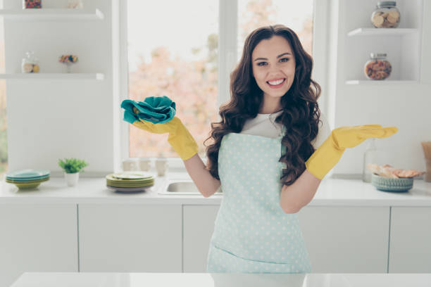 ritratto di lei lei bella bella affascinante attraente bella allegra a pelo ondulato casa-moglie lucidatura lucido tavolo lucido fatto risultato in moderno bianco chiaro interni interni camera d'albergo - cleaning domestic kitchen white duster foto e immagini stock