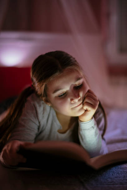istock Girl child reads book in bed 1132024973