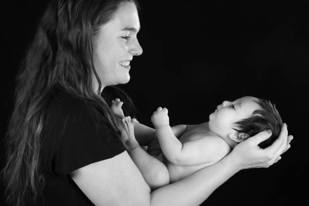 Side view of a smiling mother looking at her infant son