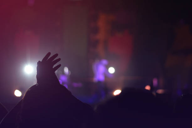 istock silhouettes of  , Fun concert party rock disco light background. 1132032019