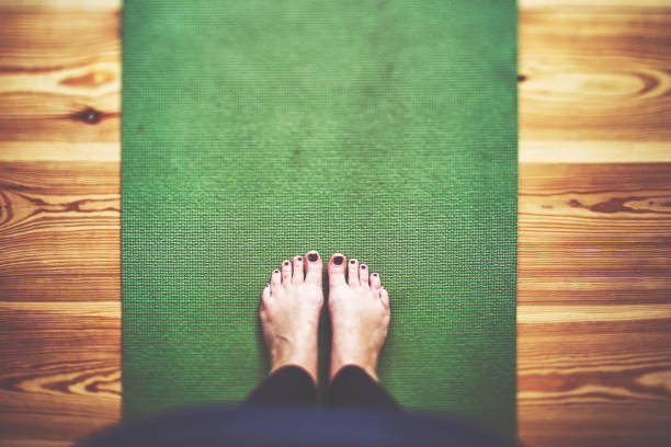 Bare feet on the green Yoga mat