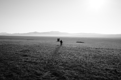 A visitor going to the restroom built in the middle of the open land of Mongolian.