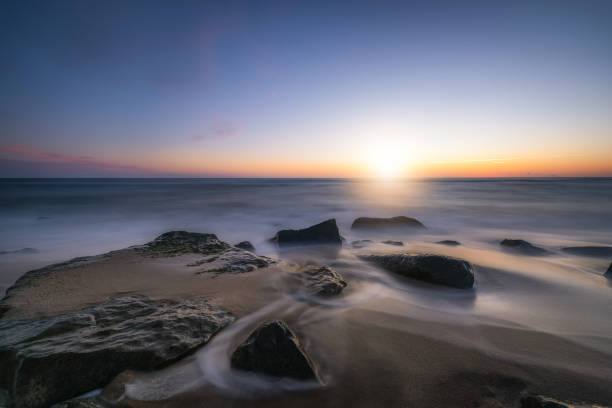 istock Tranquil sunrise over a rocky beach 1132036804
