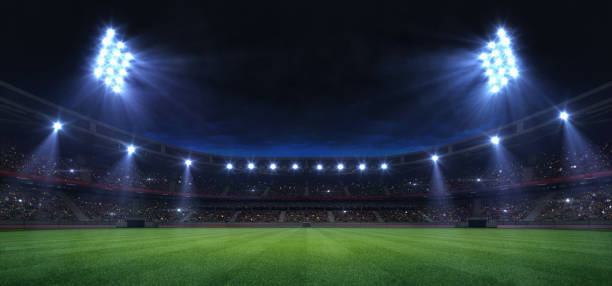 スポットライトと空の緑の草の遊び場によって照らさユニバーサル草フィールドスタジアム - soccer player flash ストックフォトと画像